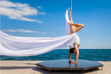 Female pole dancer against the sea and sky