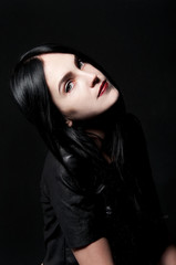 Fototapeta premium Gorgeous brunette with white skin, red lips on black backdrop