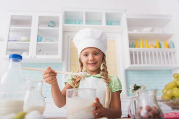 Cheerful girl baking with inspiration