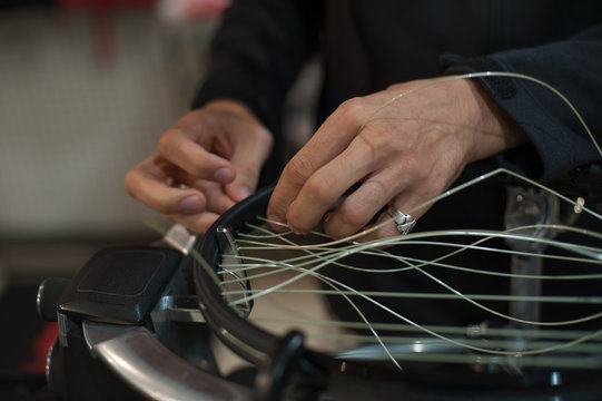 Stringing Machine. Close up of tennis stringer hands doing racket stringing in his workshop