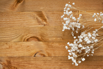 white flowers gypsophila. small white flowers on a wooden background. wood texture. space for text. view from above