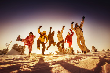Snowboarders posing on blue sky backdrop in mountains