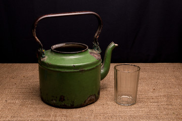 The old iron kettle and faceted glass on the table