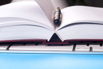 Close-up of open book and pen.