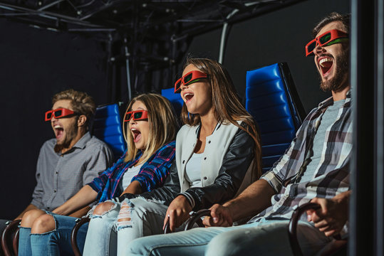 four people laugh at cinema