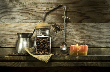 Coffee beans in a glass jar and spoon on shelf.