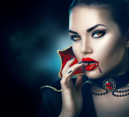 Halloween portrait. Beauty sexy vampire woman with dripping blood on her mouth - obrazy, fototapety, plakaty