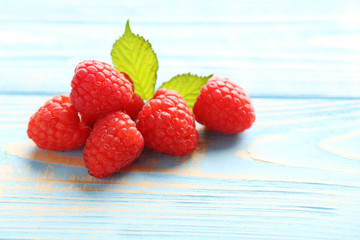 Red raspberries on a blue wooden table