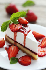 Strawberry cheesecake on plate on grey wooden table
