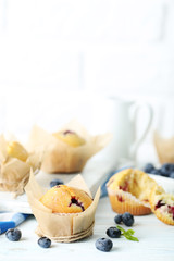 Muffins with blueberries on blue wooden table