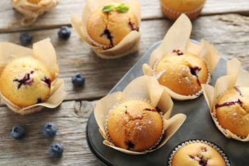 Muffins with blueberries on grey wooden table