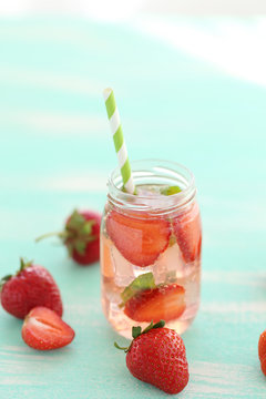 Fresh strawberry drink in bottle on wooden table