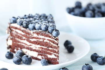 Tasty piece of cake with blueberries on wooden table
