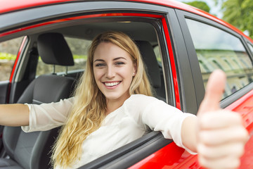 Happy smiling girl in a red car.