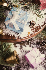 Christmas composition with presents and decoration on wooden cake stand. Retro style toned christmas greeting card.
