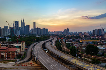 Obraz na płótnie Canvas Dramatic scenery of elevated highway heading towards Kuala Lumpur city center at sunset.