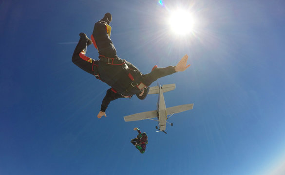 Two skydivers jump from an airplane