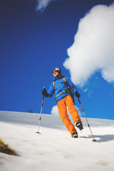 Mountain climber walks on a snowy slope.