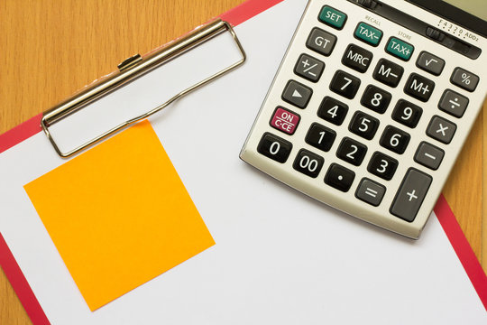 Paper on red file with calculator and orange note