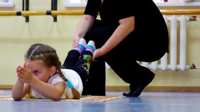 Girl doing stretching back by a teacher