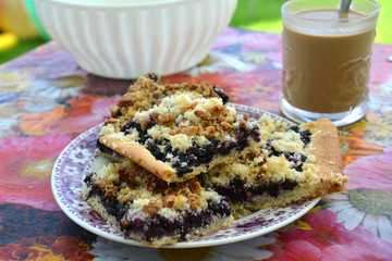 Delicious homemade dessert with blueberries on a plate and cup of coffee.