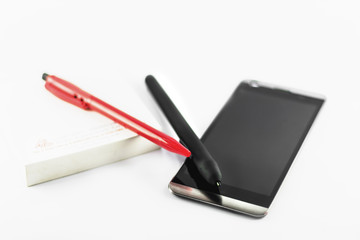 Smartphone pen and red pen on notebook
