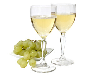 Fototapeta premium two glasses of sparkling white wine. green grapes on a white plate. isolated on white background