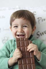 happy kid eating a tablet of chocolate
