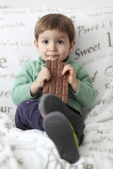 baby boy eating a tabletof chocolate
