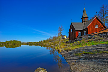 Small wooden church on lake shore