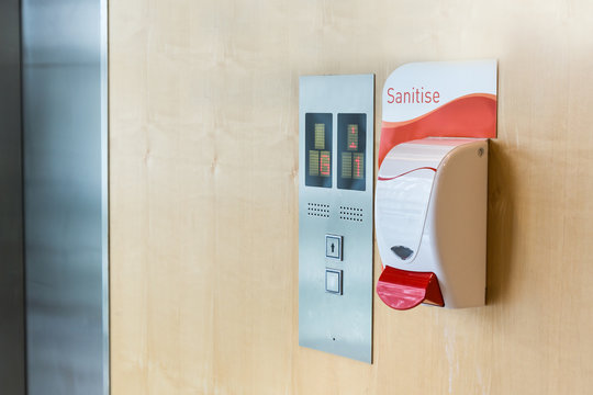 Public hand sanitizer next to elevator