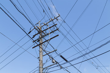 Electricity pole with wires grid with blue sky