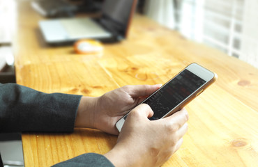 Business woman in read on cell phone, Wood table background.