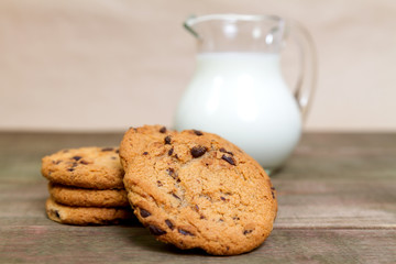 Homemade corn and oat biscuits with chocolate and milk in glass jug
