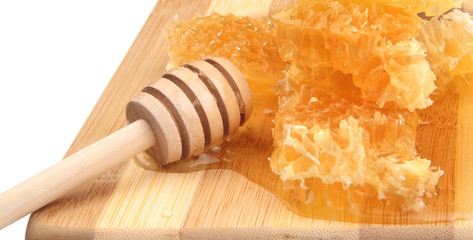 honeycomb honey with diper on a wooden cutting board, white background