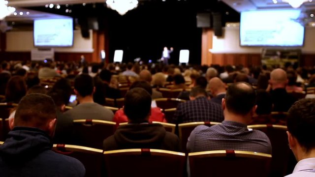 lecturer tells presentation on the scene to packed house of listeners