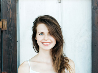 Fototapeta premium Beautiful girl smiles against shutters