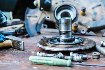 Old, oiled wheel hub lies on a wooden table