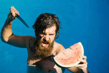man with watermelon and knife in pool - Powered by Adobe