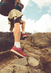 Female hiker walking through the rocky land.