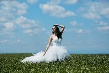 pretty wedding girl on green grass and sky