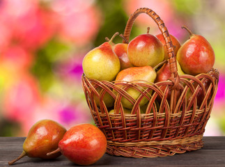 pears in a wicker basket on  wooden table with  blurred background