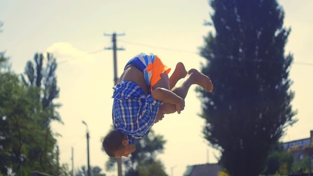 male athlete doing gainer on the beach in slow motion