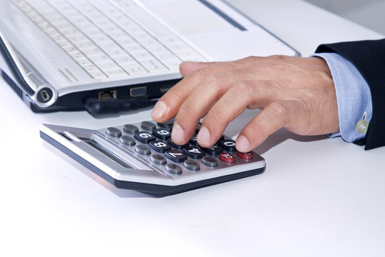 hands of businessman in the office with computer and calculator