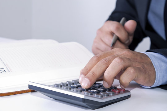hands of businessman in the office with calculator