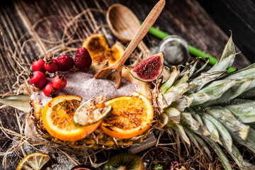 Berry smoothie with berries in pineapple on rustic background