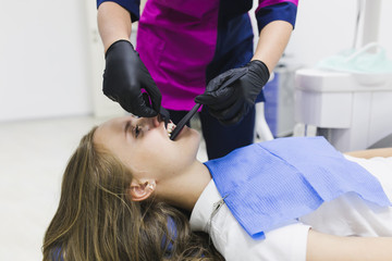 Dentist curing a female patient 
