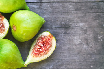 Fresh ripe green figs on rustic grey wooden table. Top view with copy space