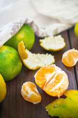 Fresh green peeled tangerines on wooden background