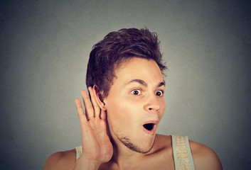 nosy shocked man with hand to ear gesture listening to gossip